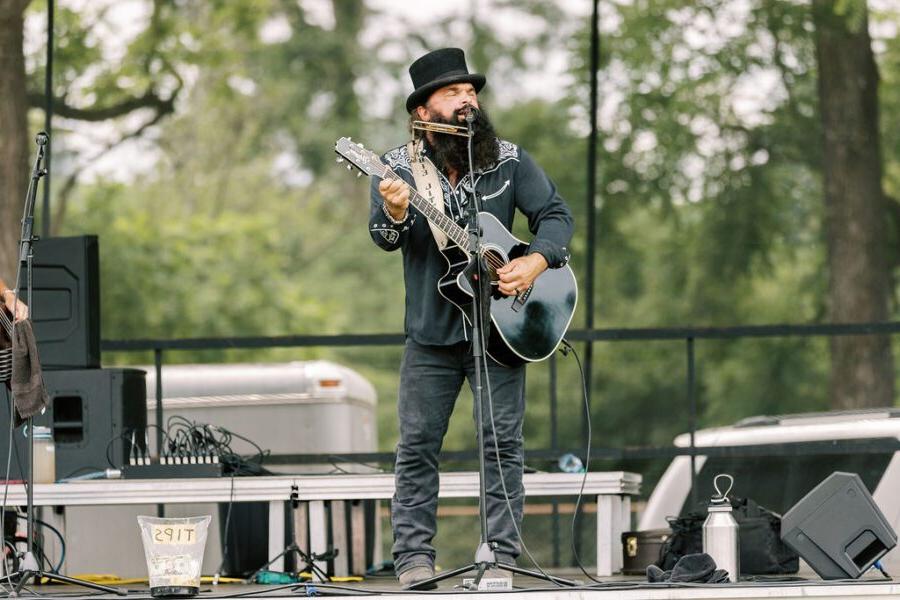 A man on stage singing and playing guitar